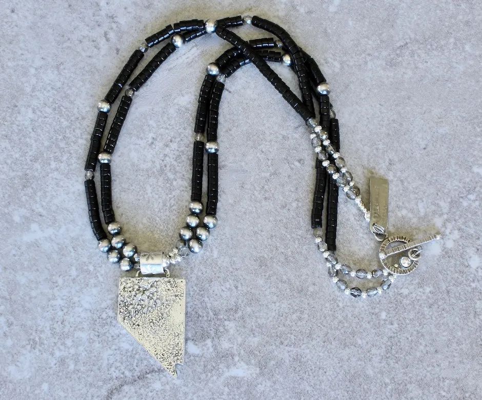 State of Nevada Reticulated Silver Pendant with 2 Strands of Black Onyx Heishi, Oxidized Sterling Silver Rounds, and a Sterling Silver Toggle Clasp